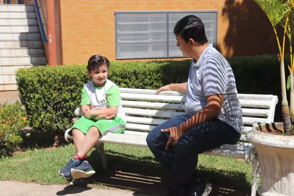 professor e alunos sentados em uma banco conversando